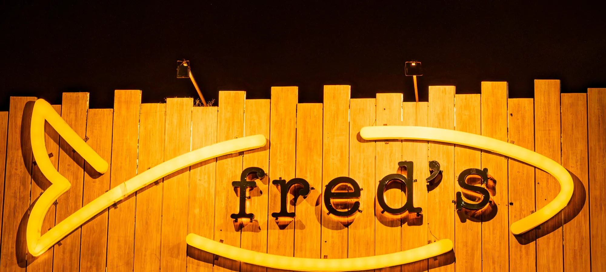 Fred’s Seafood & Raw Bar neon sign lit up at night